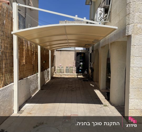 סככה מותקנת בחצר עם קיר אבן